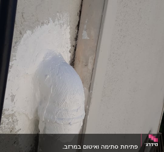צינור אטום בחומר לבן על קיר חיצוני